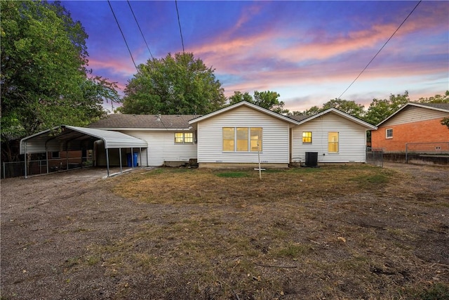 back house at dusk featuring a carport