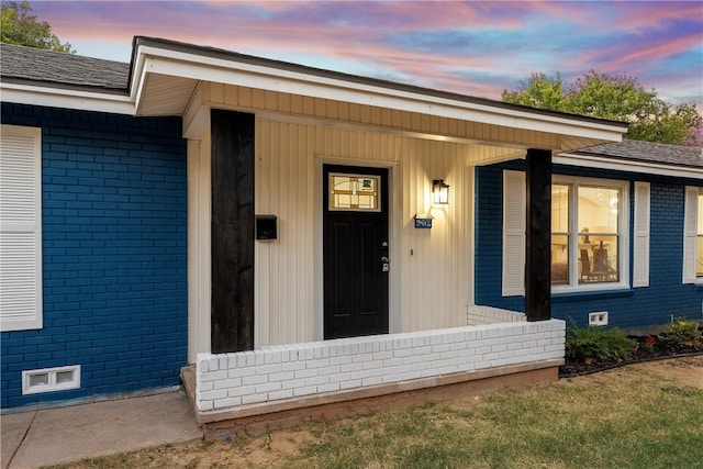 exterior entry at dusk featuring covered porch