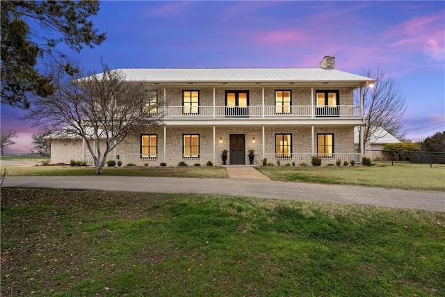 view of front of property with a porch and a yard