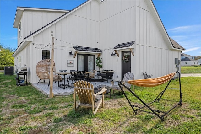 back of property featuring a lawn, french doors, cooling unit, and a patio