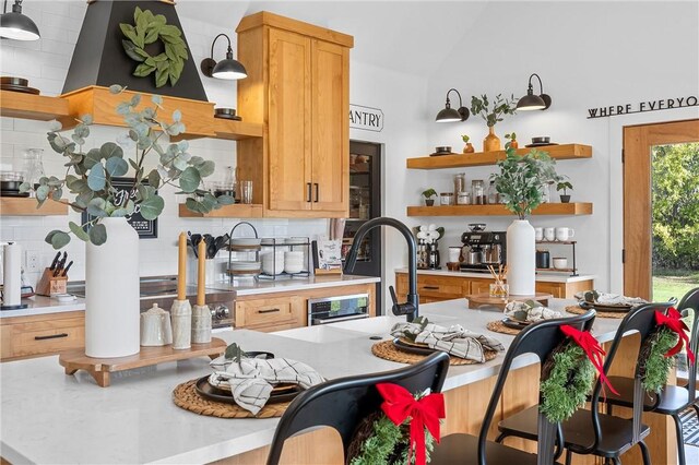 kitchen with tasteful backsplash, hanging light fixtures, lofted ceiling, and sink