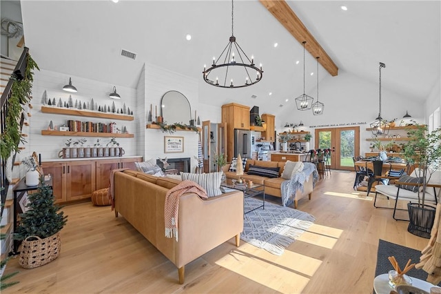 living room featuring beam ceiling, a large fireplace, light hardwood / wood-style floors, and high vaulted ceiling