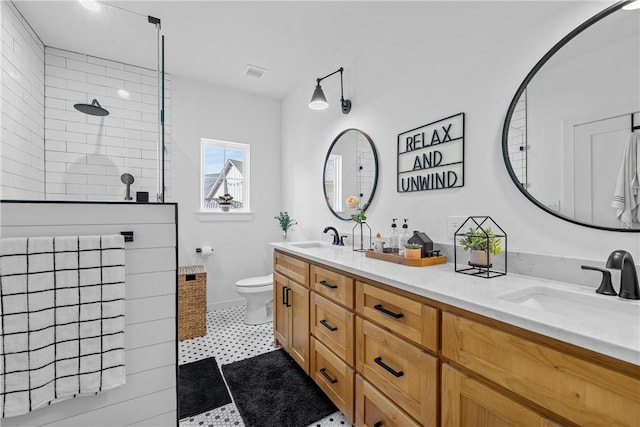 bathroom featuring vanity, toilet, and tiled shower