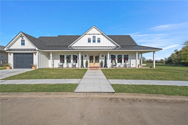 modern inspired farmhouse with covered porch, french doors, a garage, and a front yard