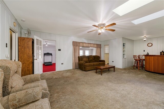 carpeted living room featuring a skylight and ceiling fan