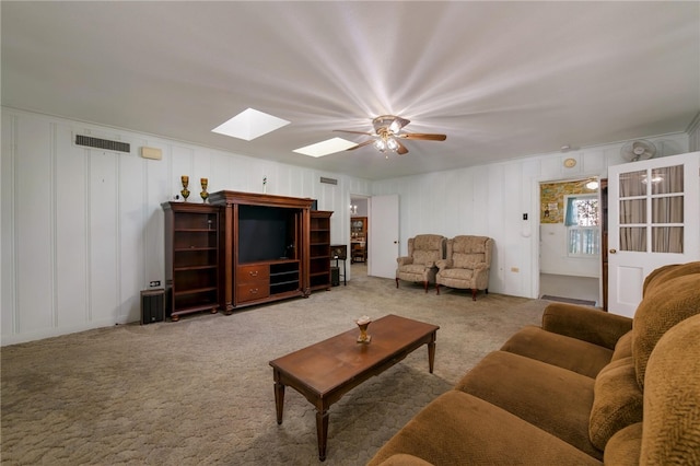 living room with carpet flooring, a skylight, and ceiling fan