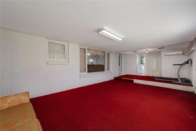 basement with a textured ceiling and a wall mounted AC