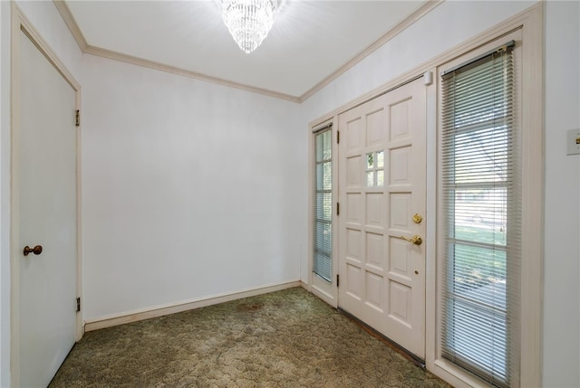 entrance foyer with crown molding, dark carpet, and a notable chandelier