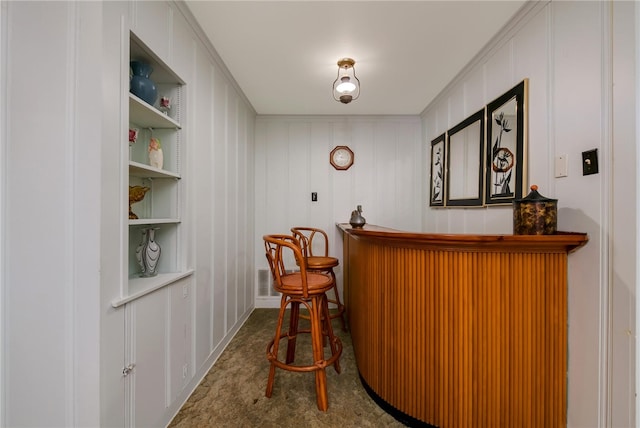 bar featuring carpet floors, built in features, and crown molding