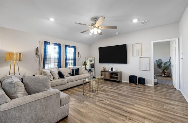 living room featuring ceiling fan, vaulted ceiling, and light hardwood / wood-style flooring