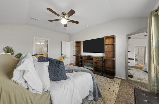 bedroom featuring carpet flooring, ensuite bathroom, vaulted ceiling, and ceiling fan