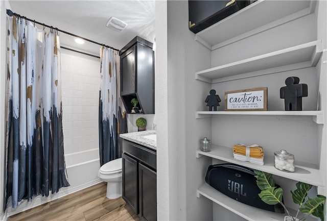 full bathroom with hardwood / wood-style floors, vanity, toilet, and shower / bath combo