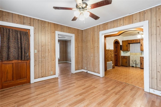 empty room featuring light hardwood / wood-style floors and wooden walls