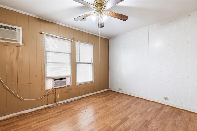 unfurnished room featuring a wall mounted AC, ceiling fan, cooling unit, light hardwood / wood-style flooring, and wood walls