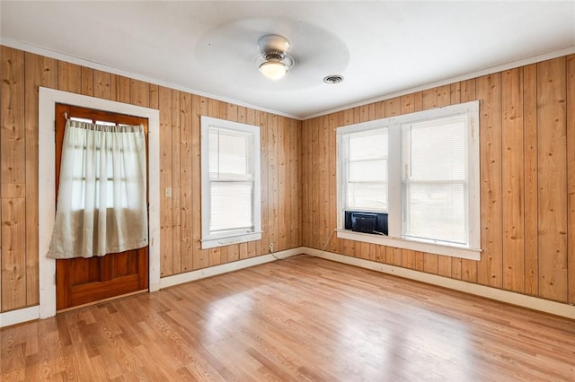 entryway with ceiling fan, wood walls, ornamental molding, and light hardwood / wood-style flooring