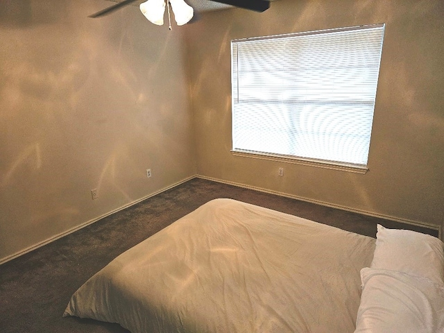 bedroom featuring ceiling fan and dark colored carpet