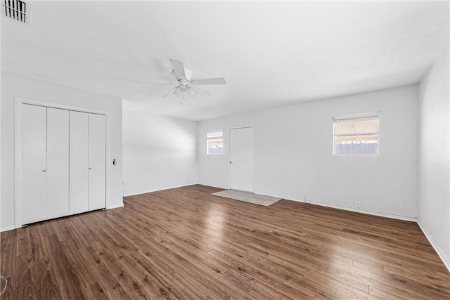 unfurnished bedroom with dark hardwood / wood-style flooring and multiple windows