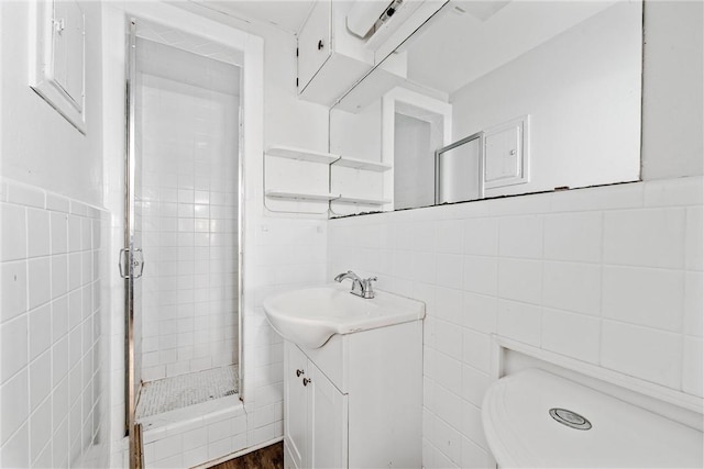 bathroom featuring vanity, tile walls, and a tile shower