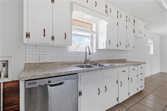 kitchen featuring white cabinetry, stainless steel dishwasher, sink, and backsplash