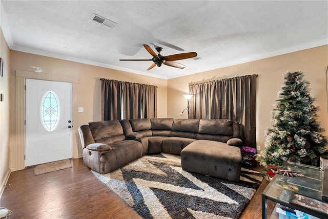 living room featuring a textured ceiling, ceiling fan, dark hardwood / wood-style flooring, and crown molding