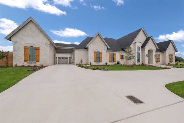 french country inspired facade featuring a front yard and a garage