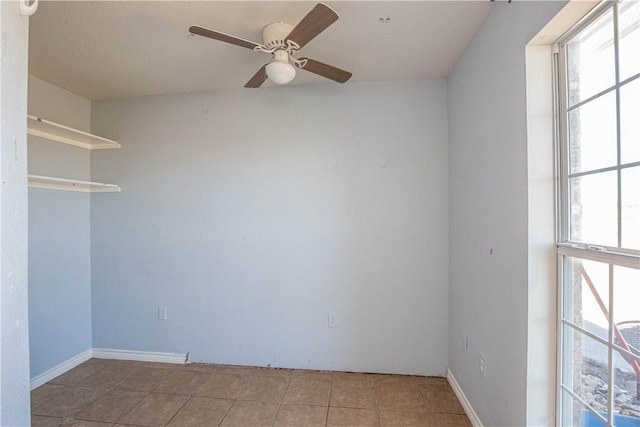 spare room with ceiling fan and light tile patterned flooring