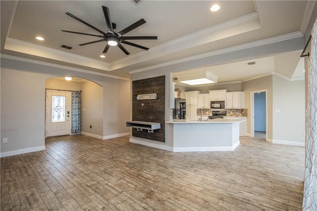 kitchen featuring refrigerator, hardwood / wood-style flooring, ceiling fan, ornamental molding, and white cabinetry