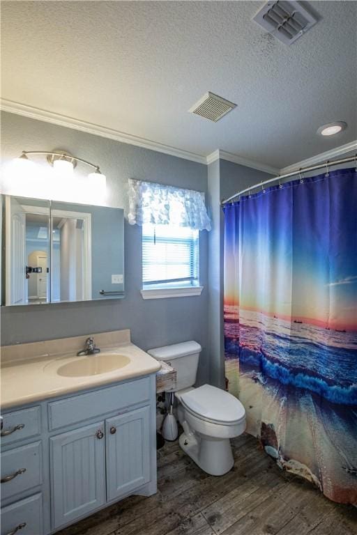 bathroom featuring hardwood / wood-style floors, vanity, toilet, ornamental molding, and a textured ceiling