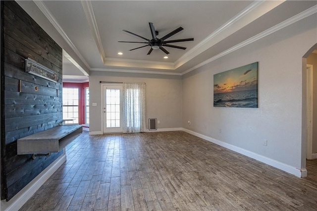 interior space featuring dark hardwood / wood-style floors, a raised ceiling, ceiling fan, and ornamental molding