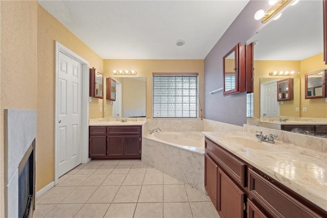 bathroom featuring tile patterned flooring, vanity, and tiled bath