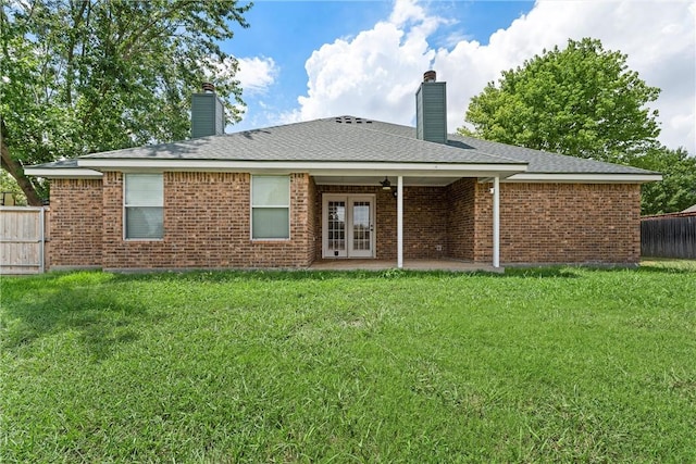 back of house with french doors, a patio area, and a lawn