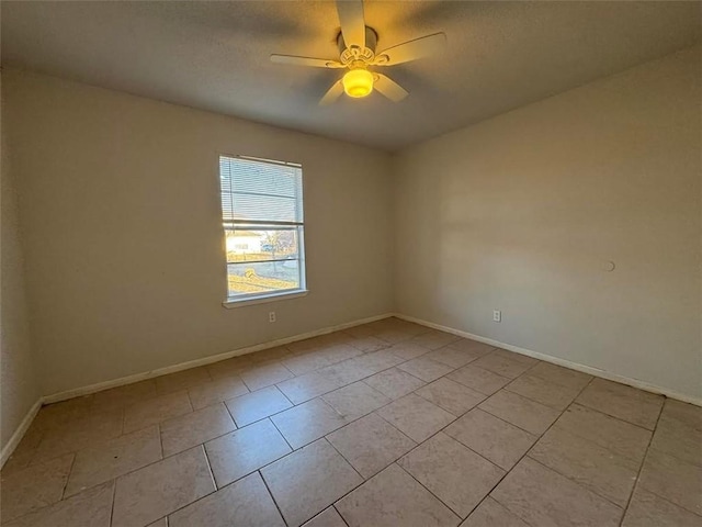 spare room featuring light tile patterned floors, baseboards, and a ceiling fan