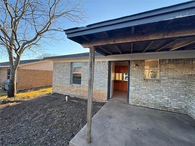 doorway to property featuring brick siding