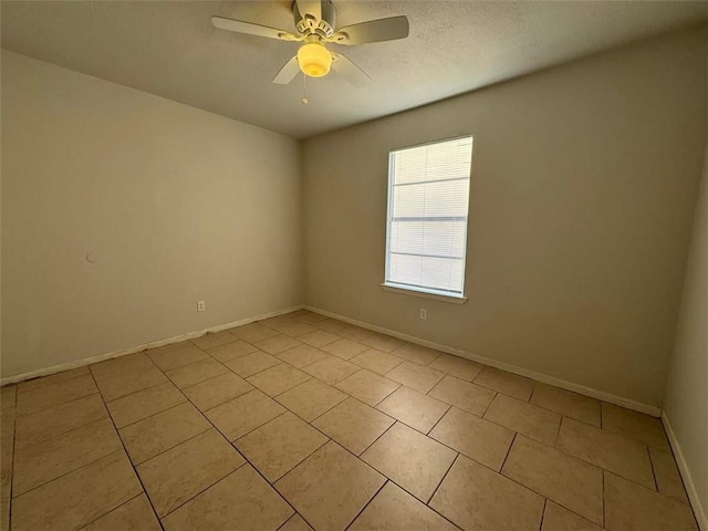 unfurnished room featuring light tile patterned floors, a textured ceiling, baseboards, and ceiling fan