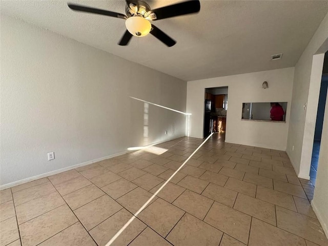 unfurnished room with tile patterned flooring, visible vents, a textured ceiling, and ceiling fan