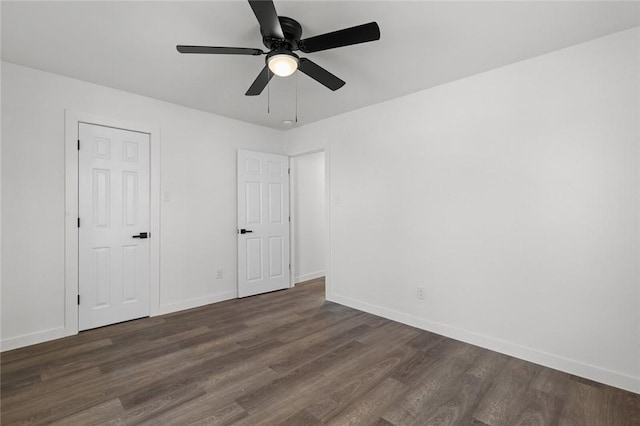 unfurnished bedroom featuring dark wood finished floors, baseboards, and ceiling fan