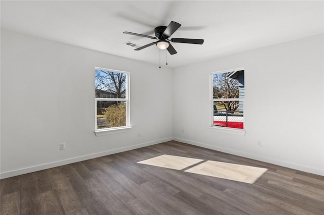 unfurnished room featuring baseboards, visible vents, ceiling fan, and wood finished floors