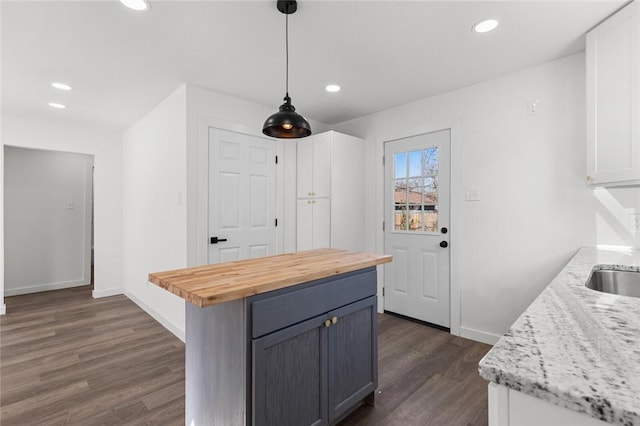 kitchen featuring recessed lighting, dark wood-style flooring, wood counters, and baseboards