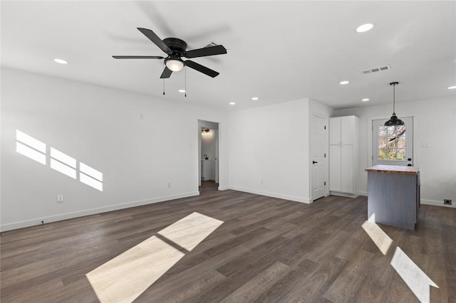 unfurnished living room featuring dark wood-type flooring, recessed lighting, visible vents, and baseboards