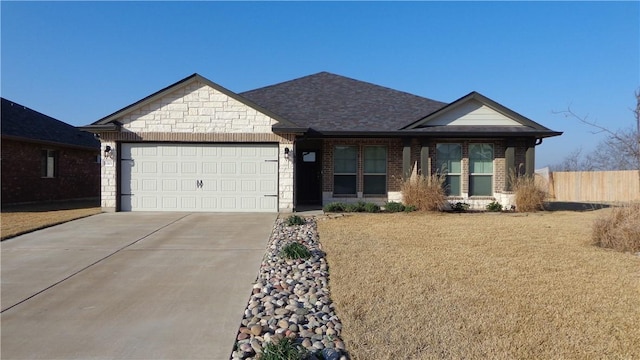 view of front facade featuring an attached garage, brick siding, fence, concrete driveway, and stone siding