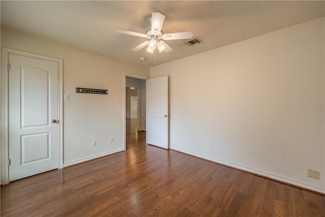 unfurnished bedroom with dark hardwood / wood-style flooring, ceiling fan, and a textured ceiling