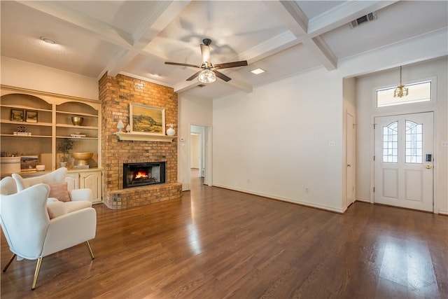 unfurnished living room with dark wood-type flooring, coffered ceiling, a brick fireplace, and beamed ceiling