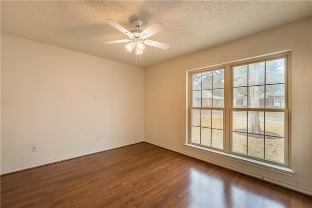 unfurnished room featuring a textured ceiling, dark wood-type flooring, and ceiling fan