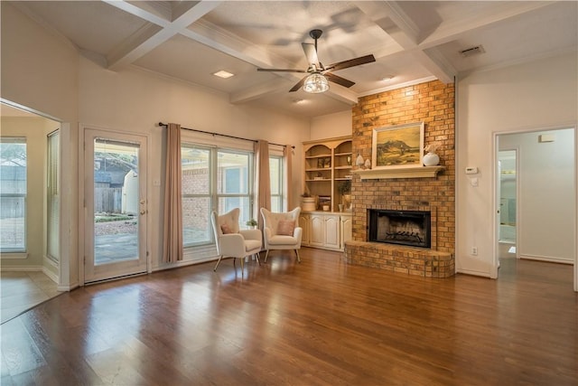 unfurnished room with ceiling fan, coffered ceiling, hardwood / wood-style floors, and a brick fireplace