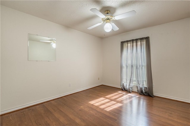 empty room with ceiling fan, hardwood / wood-style floors, and a textured ceiling