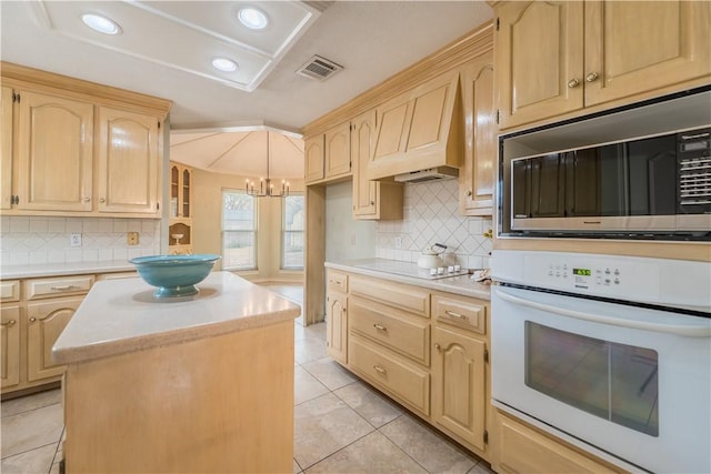 kitchen with custom exhaust hood, tasteful backsplash, light tile patterned floors, a kitchen island, and white appliances