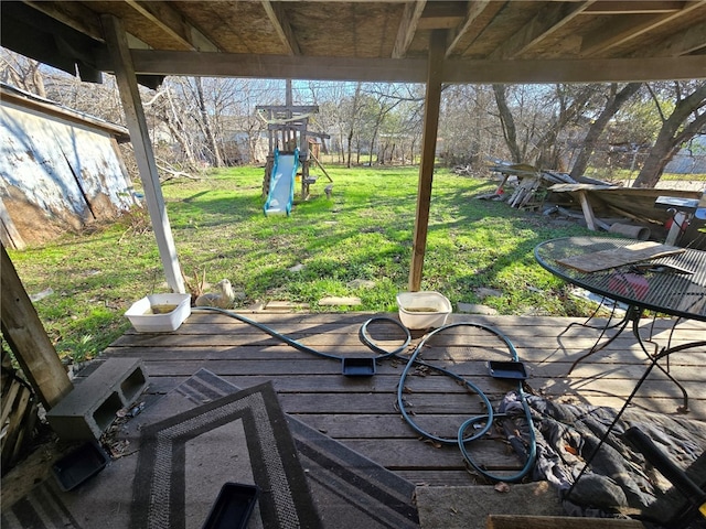 wooden terrace featuring a playground and a yard