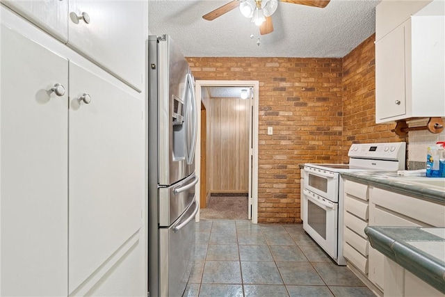 kitchen featuring stainless steel refrigerator with ice dispenser, white cabinetry, white range with electric stovetop, and brick wall