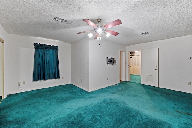 spare room featuring ceiling fan, a textured ceiling, and dark colored carpet