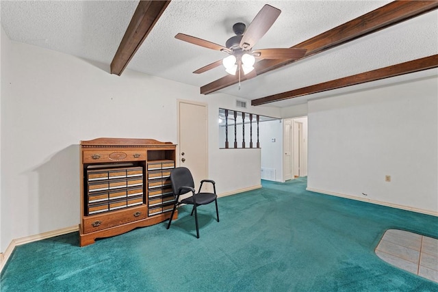 sitting room with carpet floors, ceiling fan, beamed ceiling, and a textured ceiling